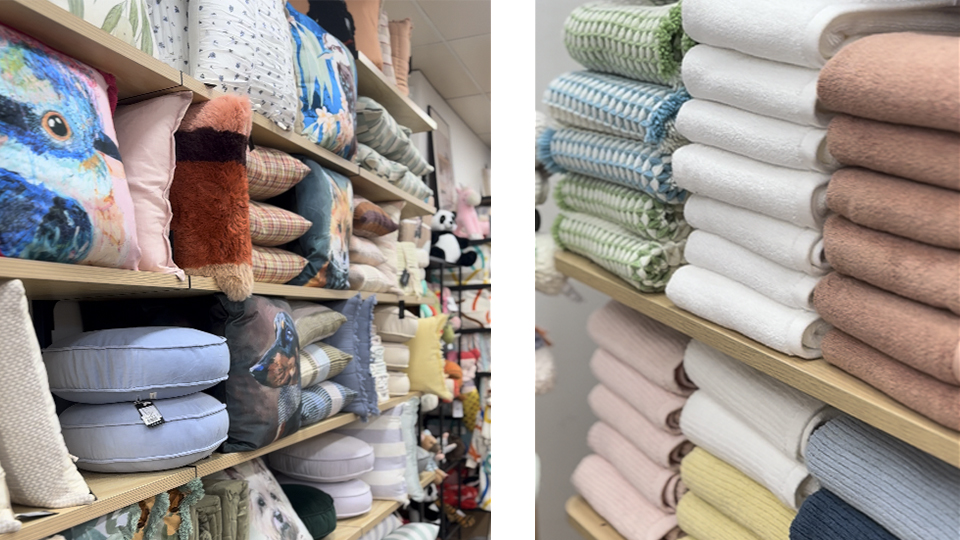 Shelves of colourful cushions and neatly folded towels and blankets in soft pastel shades.