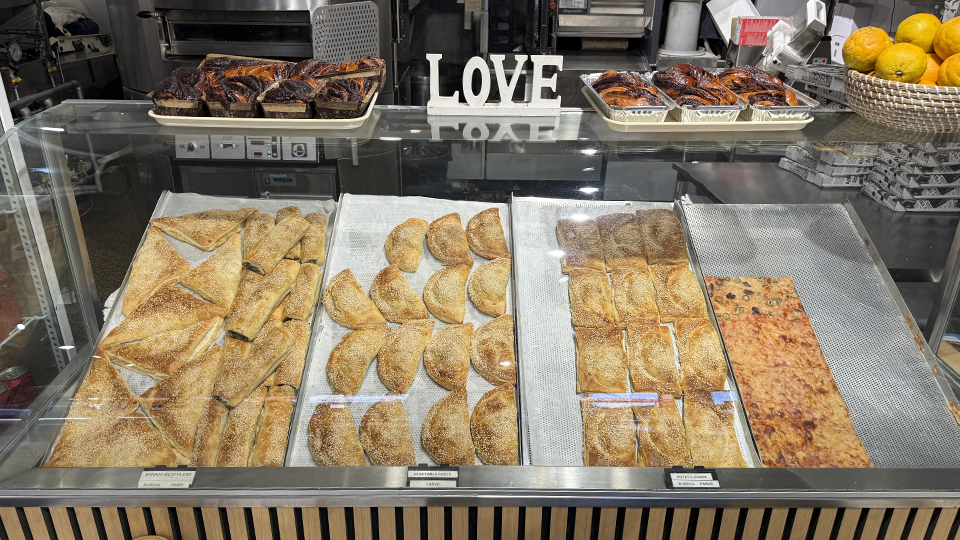 Freshly baked savoury pastries and breads displayed behind the counter at Mister Baker in Elsternwick Village.