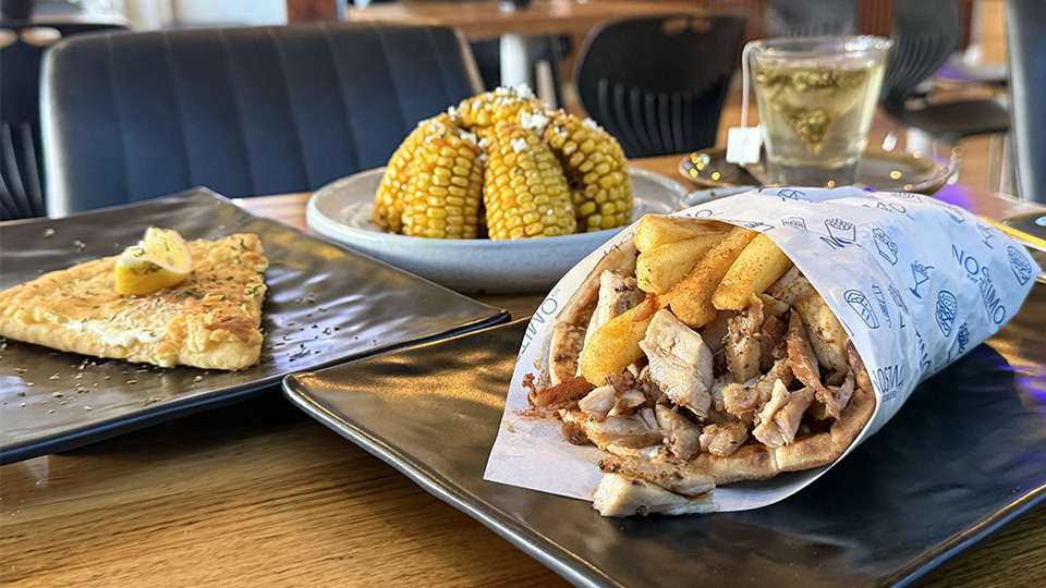 Photo of a souvlaki, a saganaki cheese slice and a beautiful plate of corn ribs